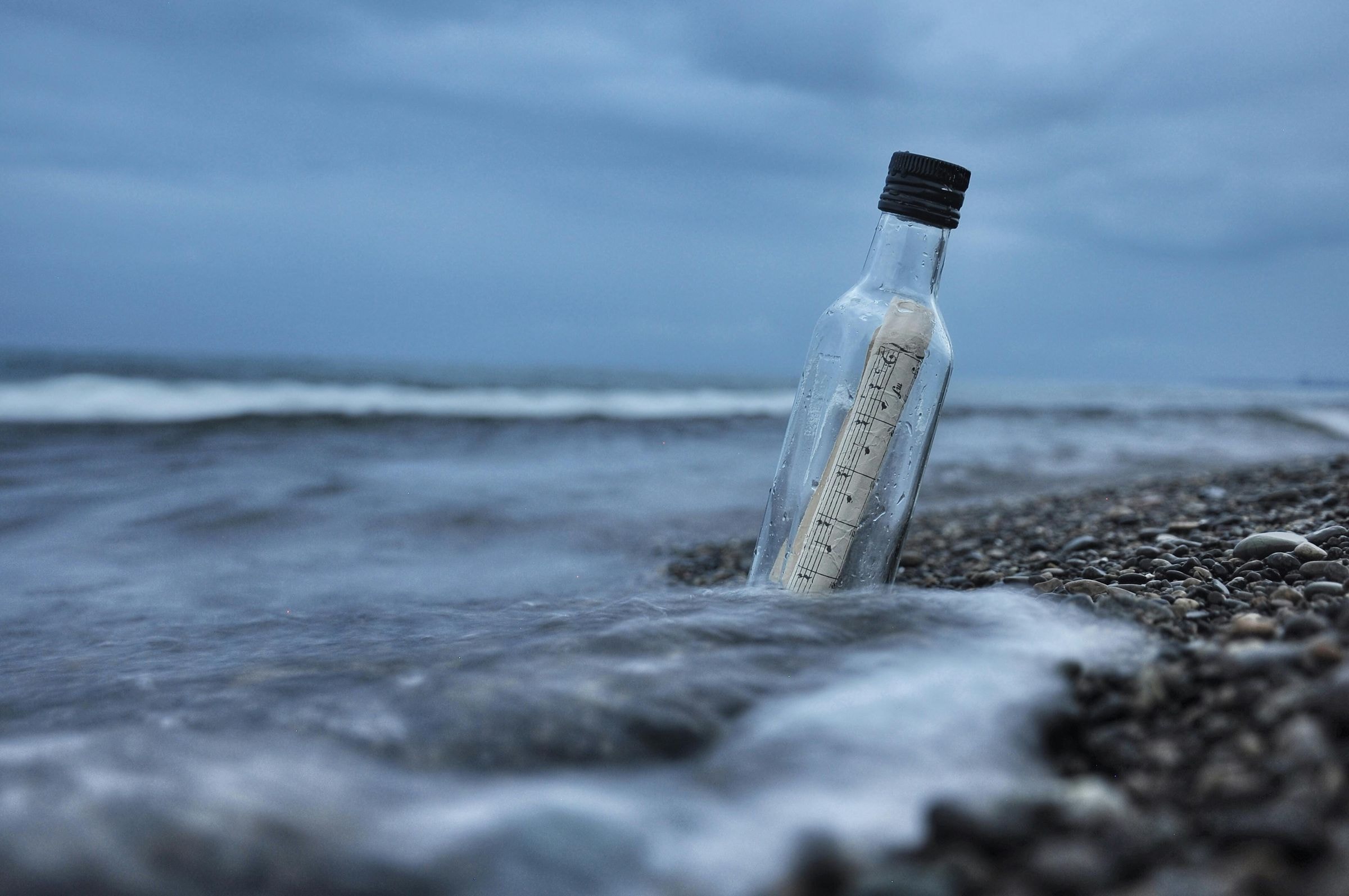 Message in a bottle on the ocean shore representing bespoke travel